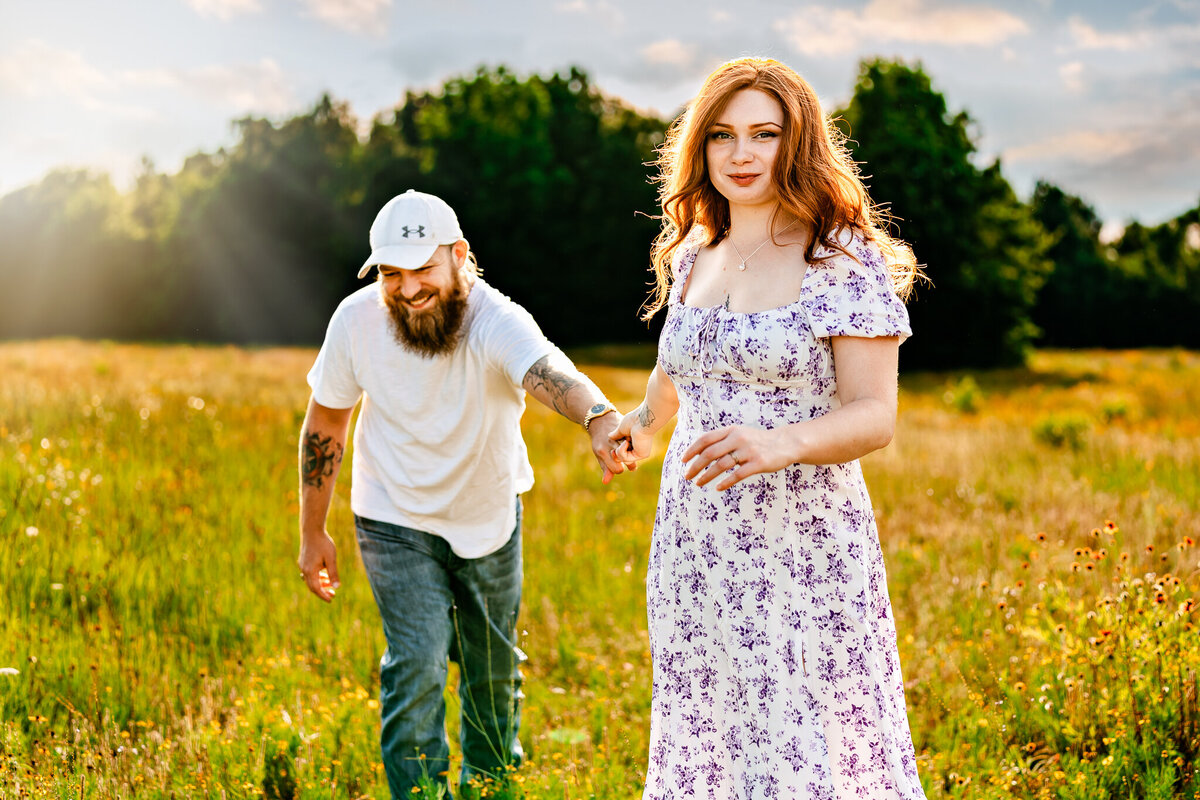 Engaged couple hold hands in a field of wild flowers at synergy park in kilgore texas