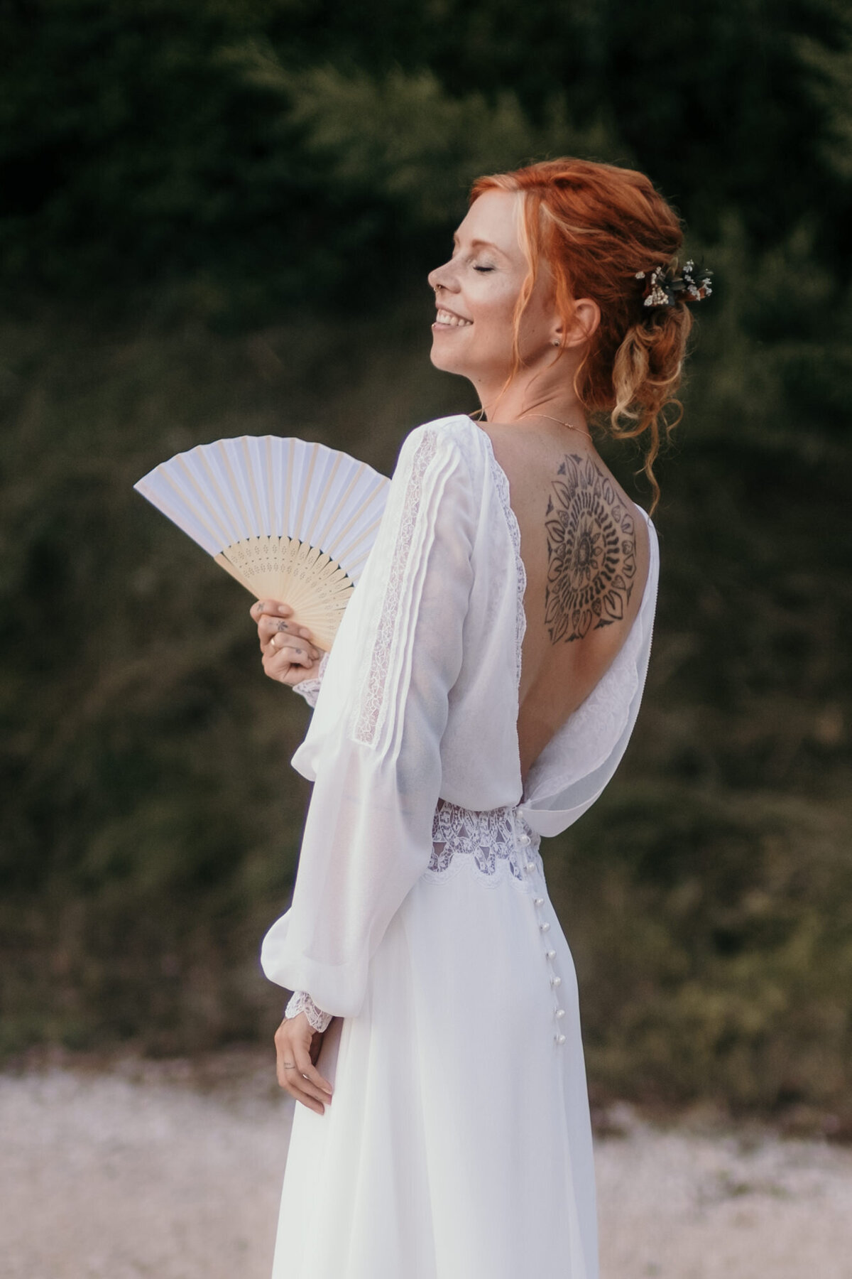 Bridal portrait with white fan at the beach.