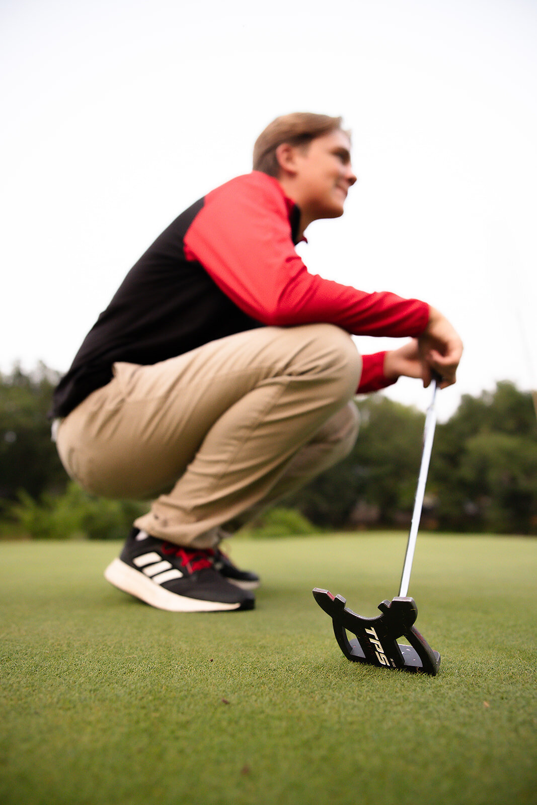 Senior boy on golf course looking at green