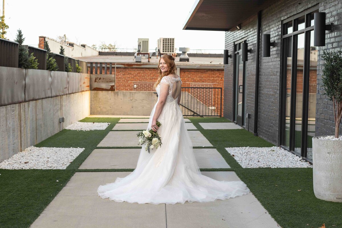 Bride looking back at camera holding wedding bouquet
