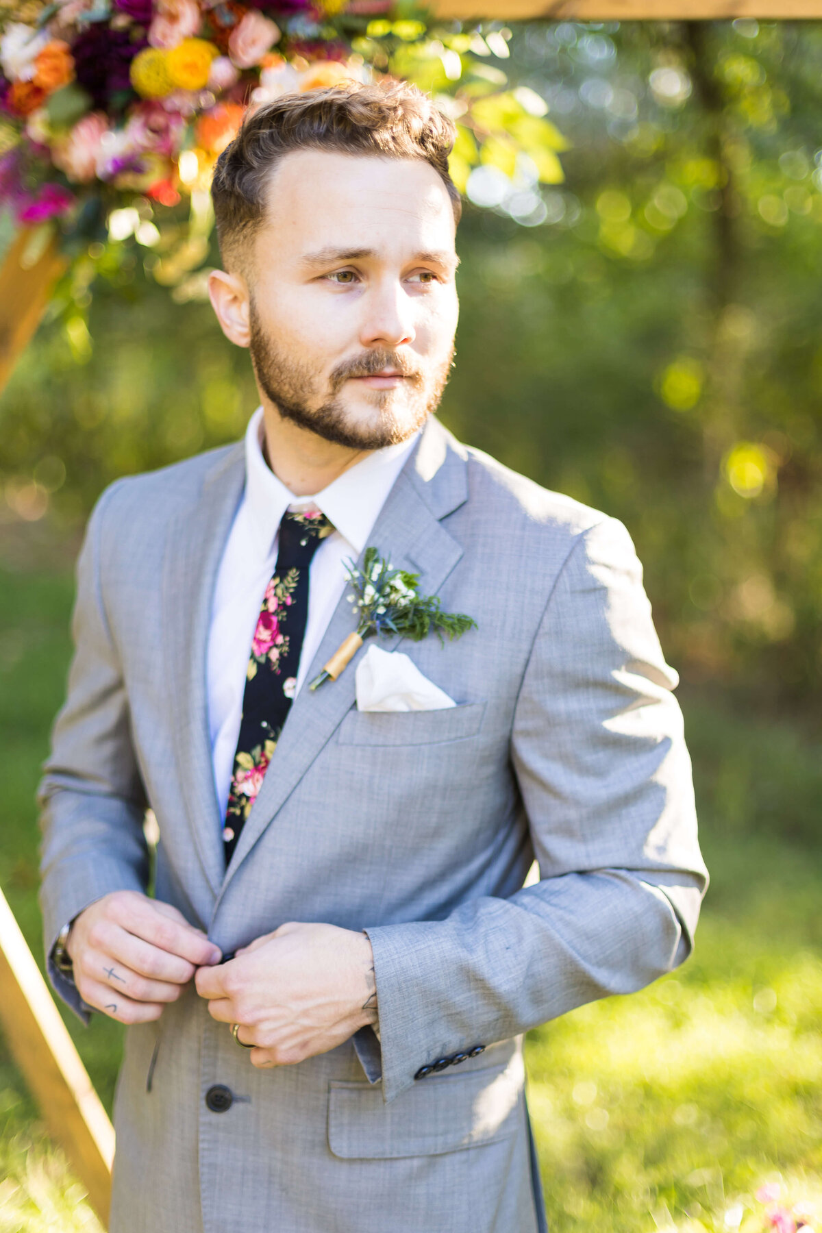 Groom buttoning up his shirt