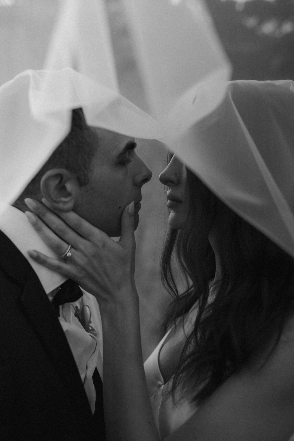 black and white photo of a couple under the veil in a super editorial shot