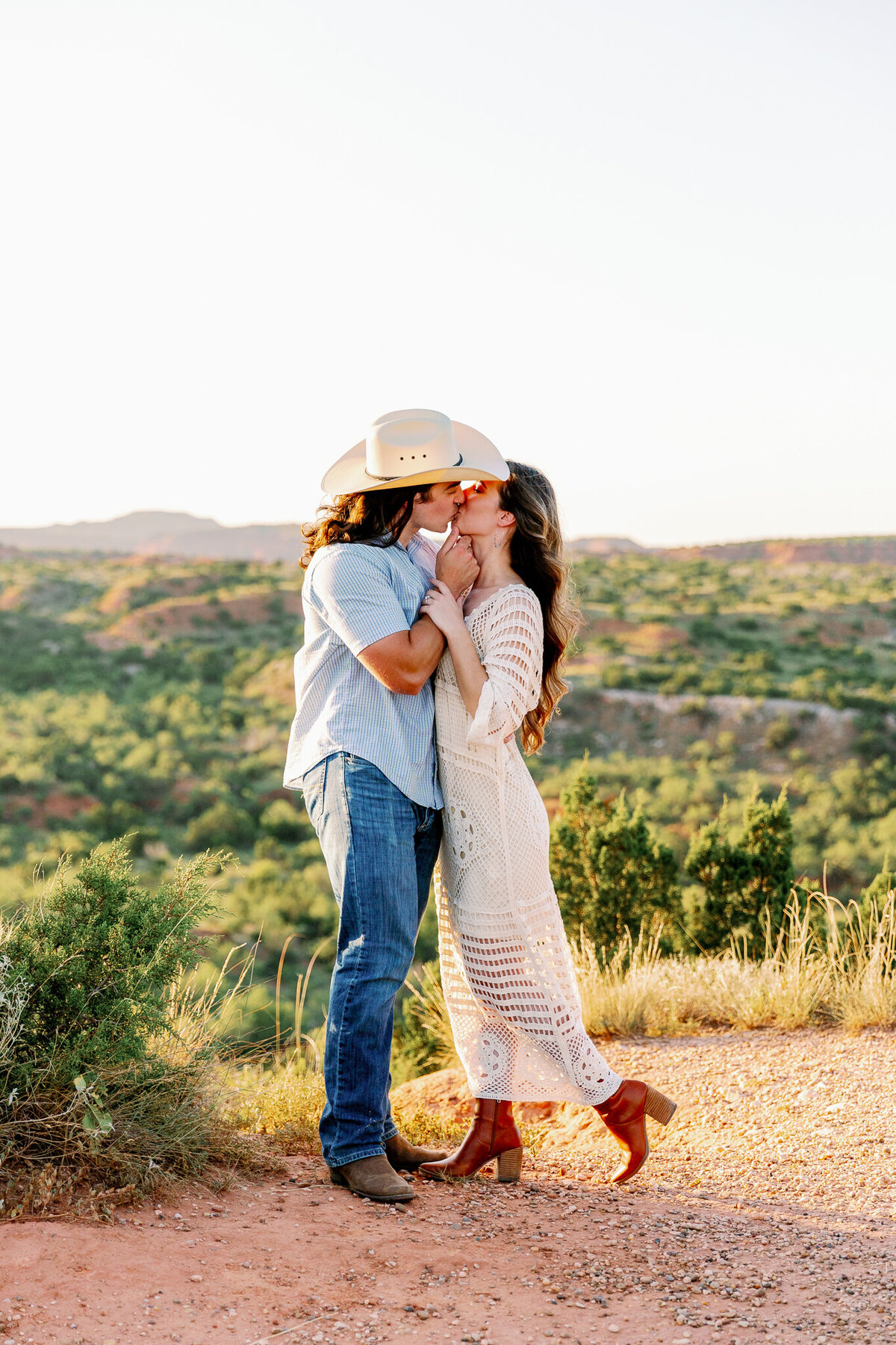Newly engaged couple embraces on the edge of Caprock Canyon