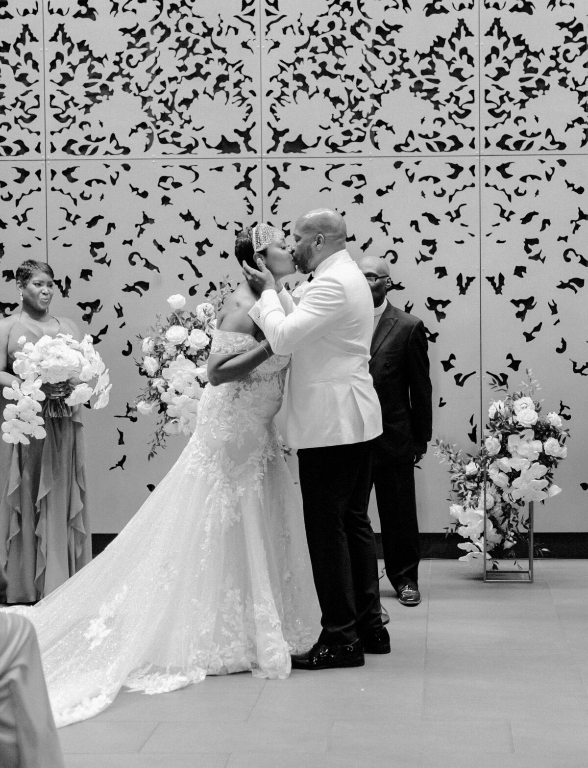 Black bride with blusher veil kisses groom at Garden Theater wedding ceremony