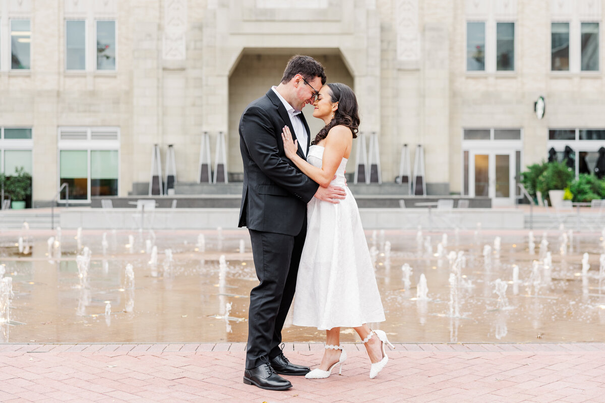 Elegant engagement portraits taken at Sundance Square in Fort Worth, TX, capturing a stylish couple in a tender moment by the iconic fountains. A classic downtown backdrop for timeless love.