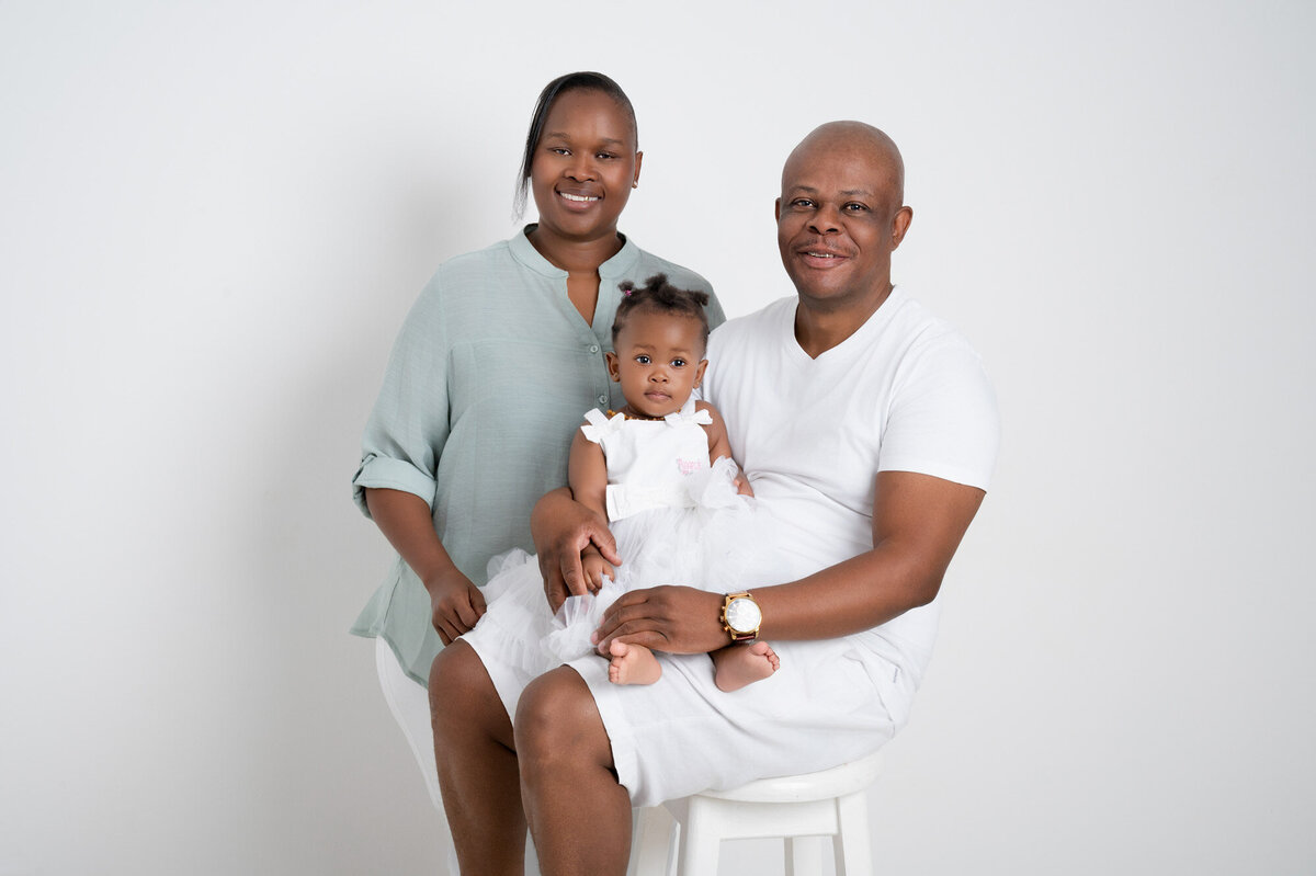 mom dad and one year old all wearing white and green