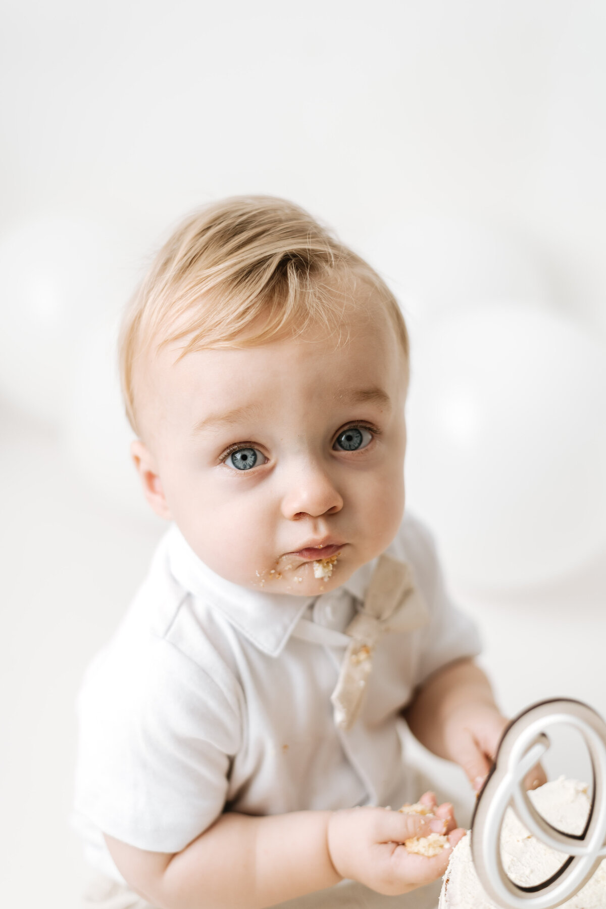 Baby boy with cake on his face at cake smash photoshoot in Billingshurst