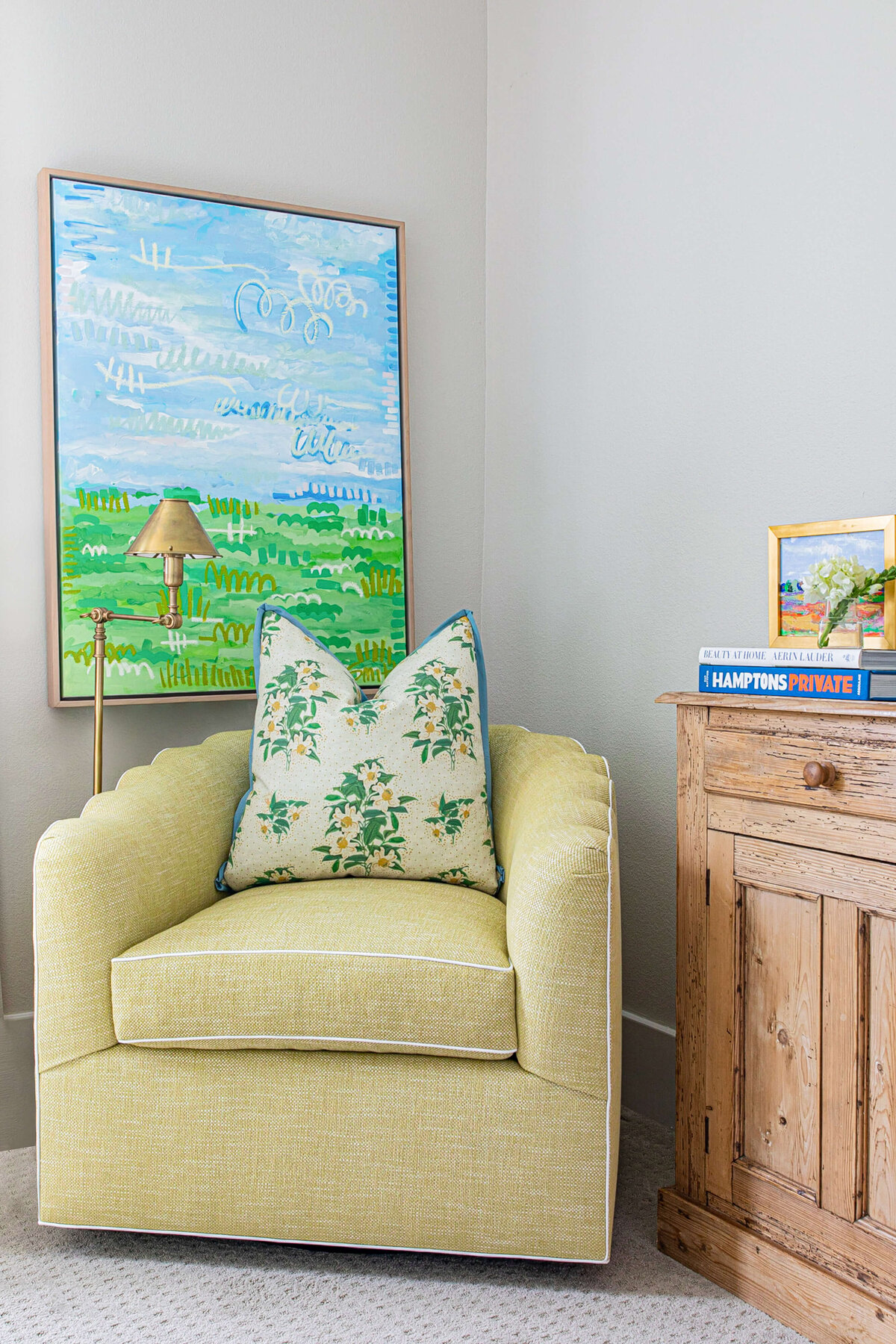 oyster creek studios aryns home yellow chair with white floral pillow and abstract landscape painting in corner