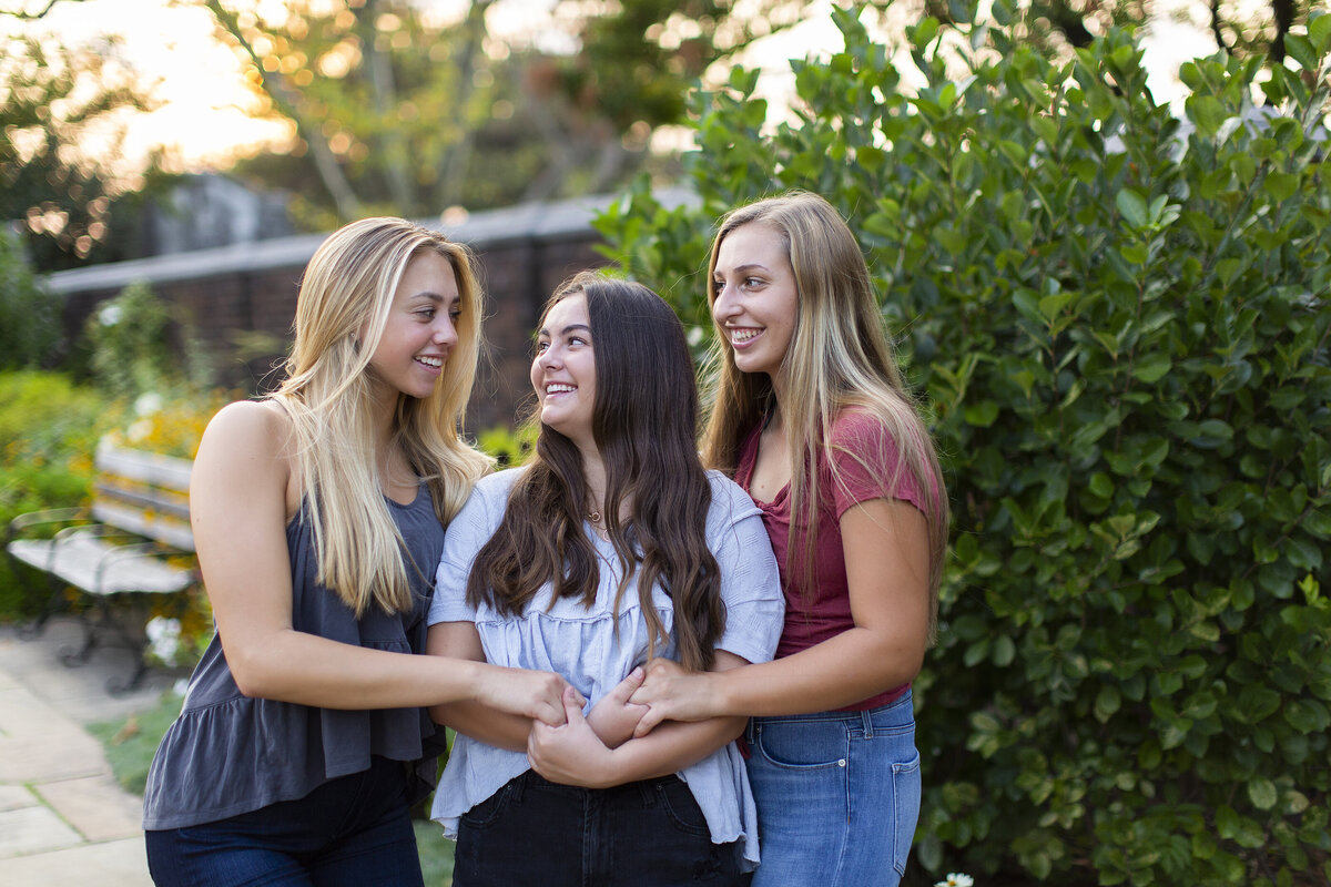 Highschool senior friends hold hands while smiling at eachouther during their senior session in Shadyside.