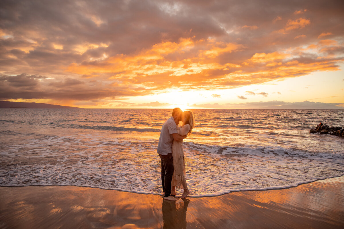 Hawaii Engagement Photographer captures man and woman kissing at sunset during beach engagement photos