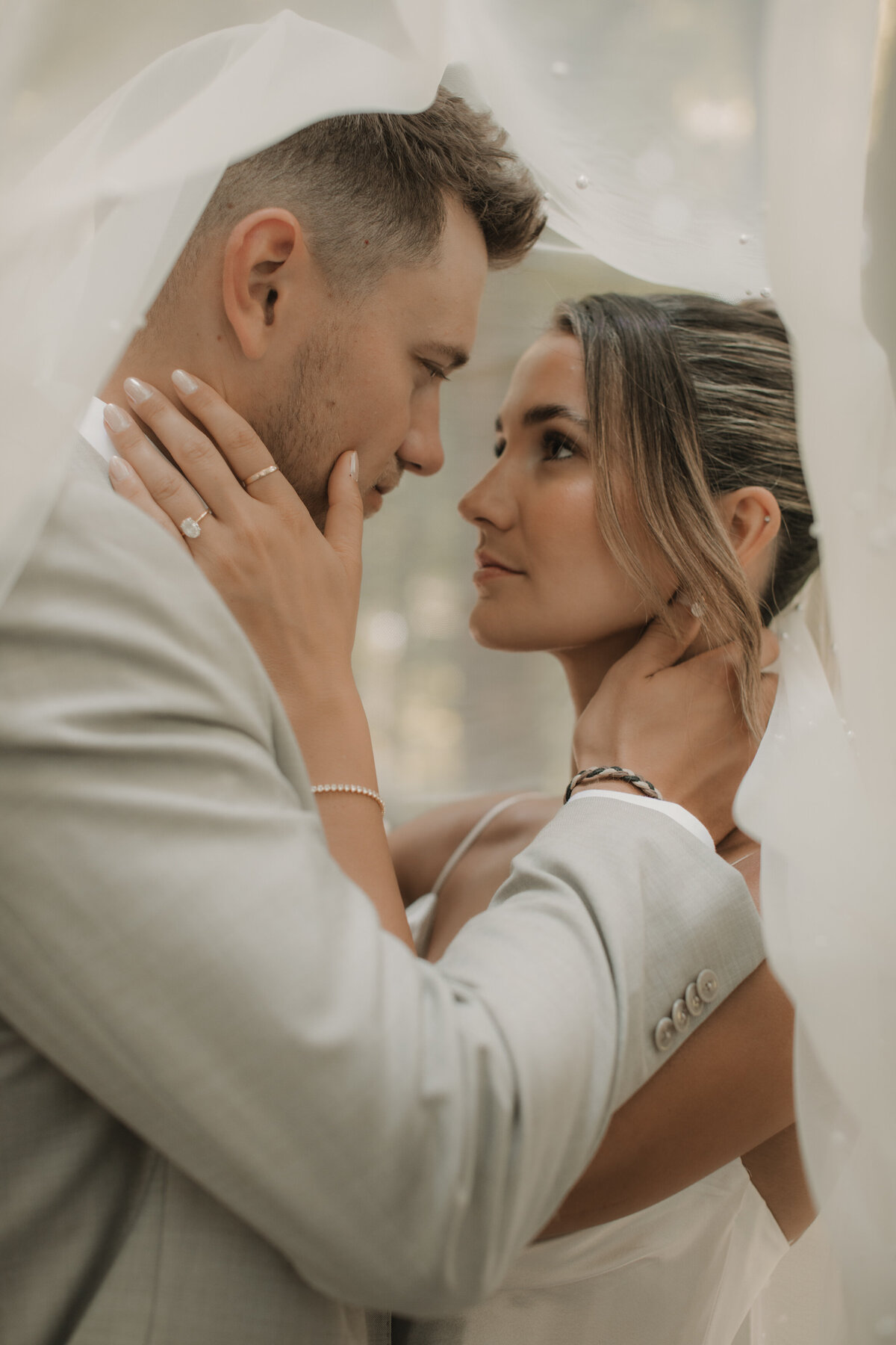 bride and groom under veil