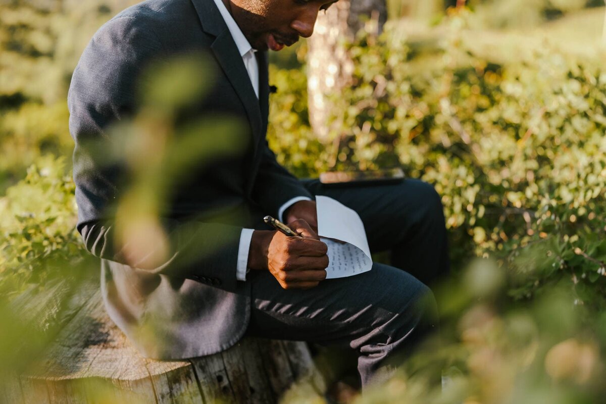 A groom writing his vows before his elopement ceremony in Idaho