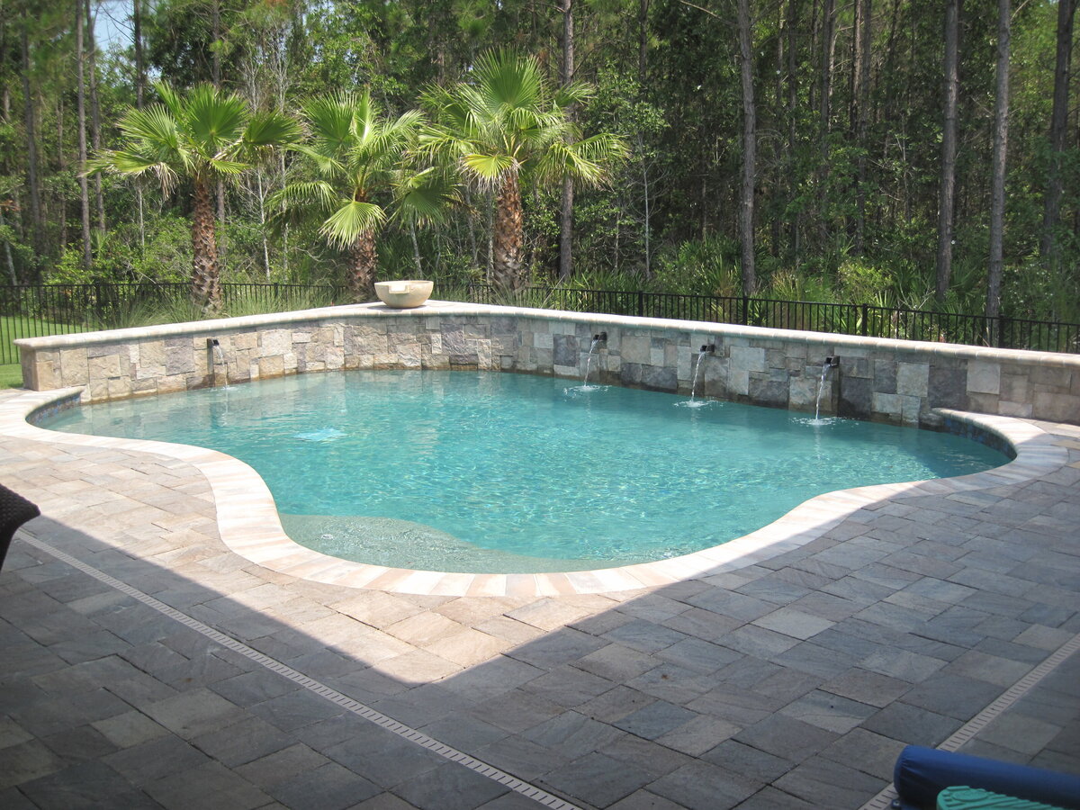 Custom pool design and build with water features and paver patio