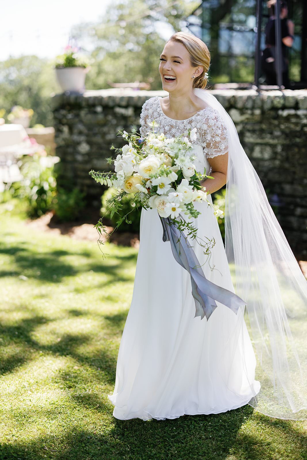 Bride laughs while holding wedding bouquet