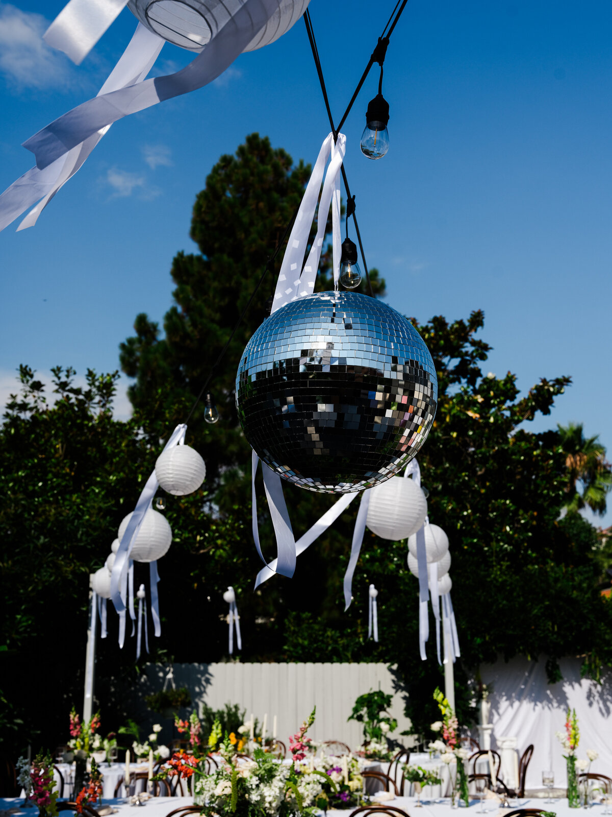 wedding decor hung up including disco ball for San Diego backyard wedding