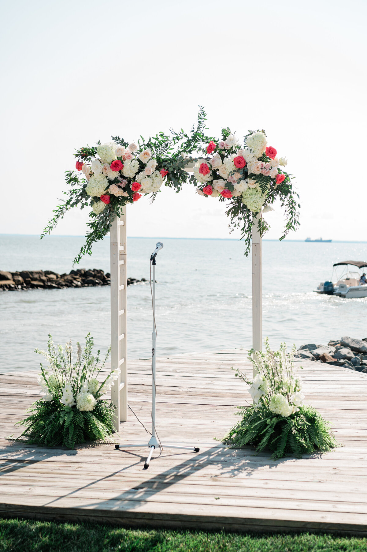 Organic floral design for a wedding at Silver Swan Bayside in Kent Island, MD. Floral arches for Eastern Shore wedding venues by The Garden Studio LLC.