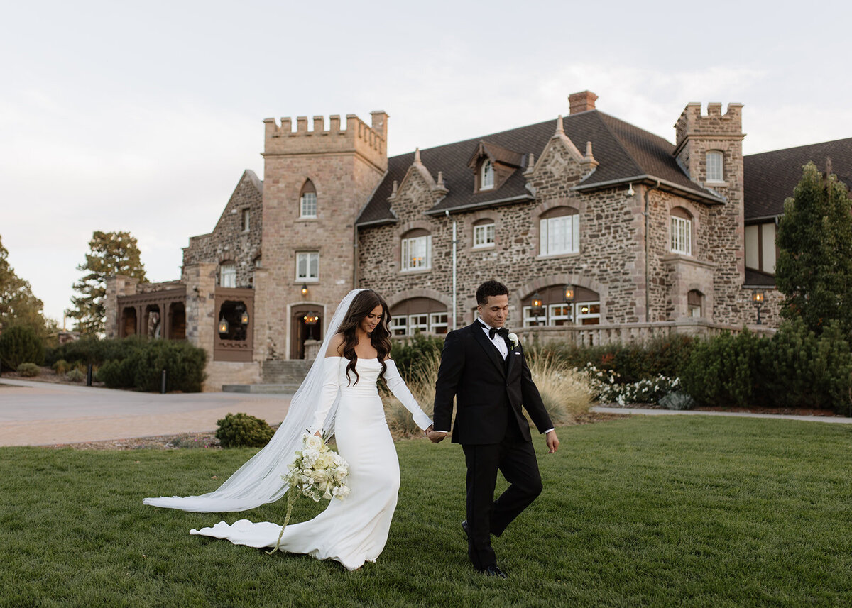Groom leading bride along mansion lawn