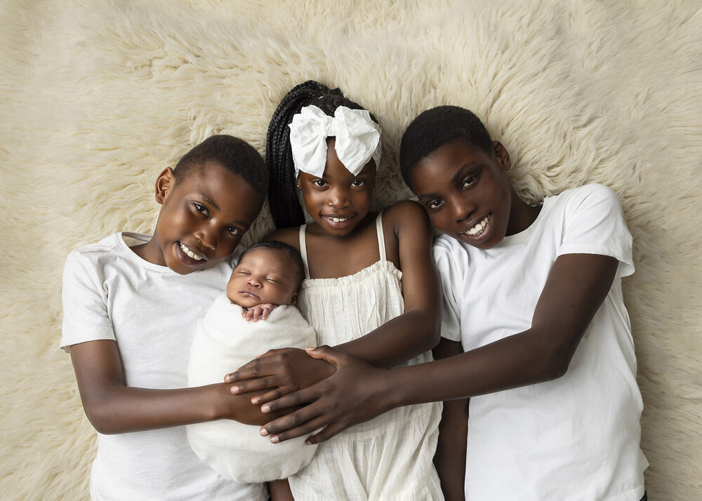 NEWBORN_BABYBOYWITHSIBLINGSLAYINGDOWNPOSE