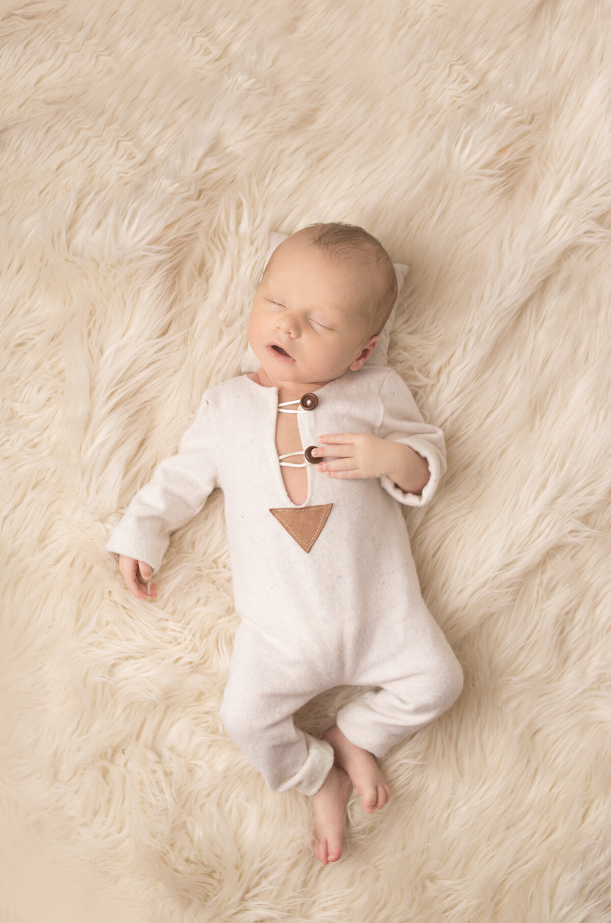 Newborn baby wearing tan outfit during newborn photoshoot in Franklin Tennessee photography studio