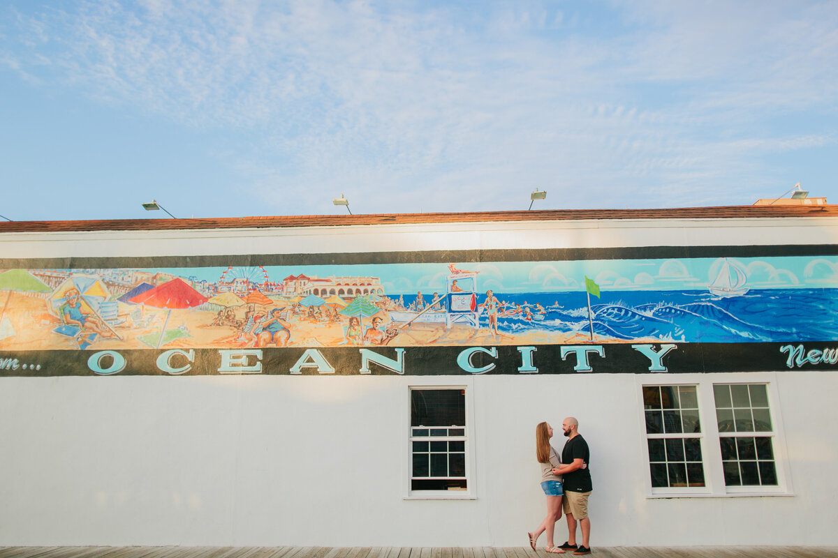 A couple standing close in front of an old marina building 