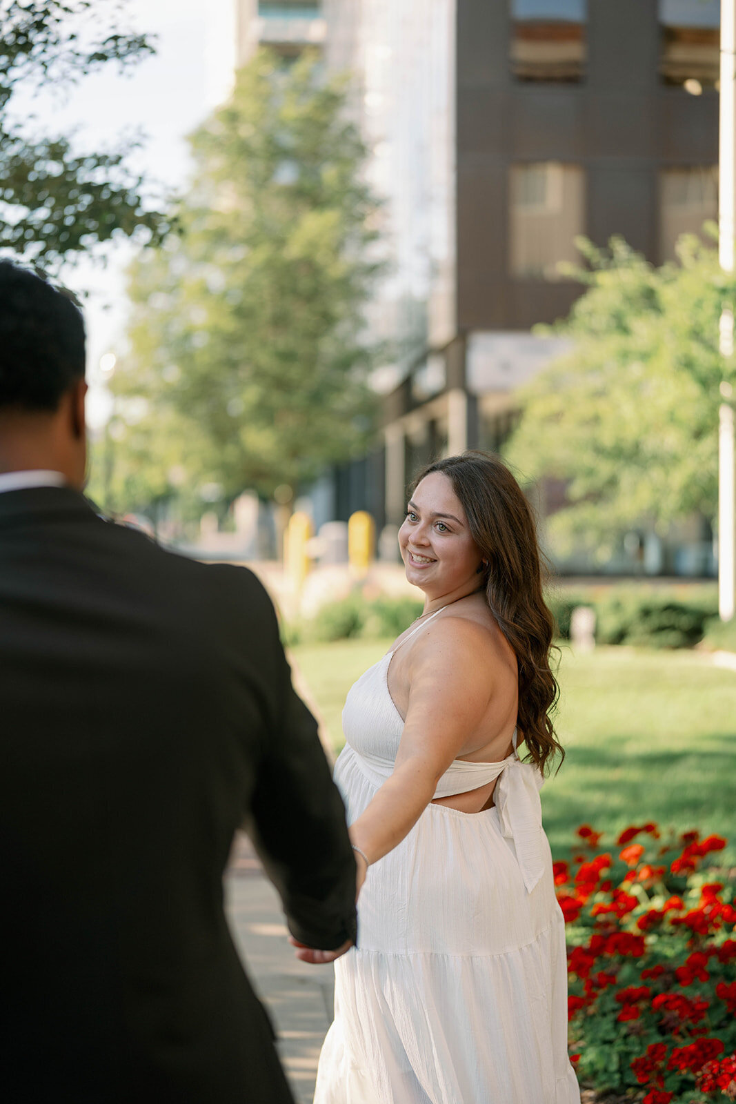 Elegant engagement portrait of fiancé helping fiancée down stone staircase in Kalamazoo, MI.