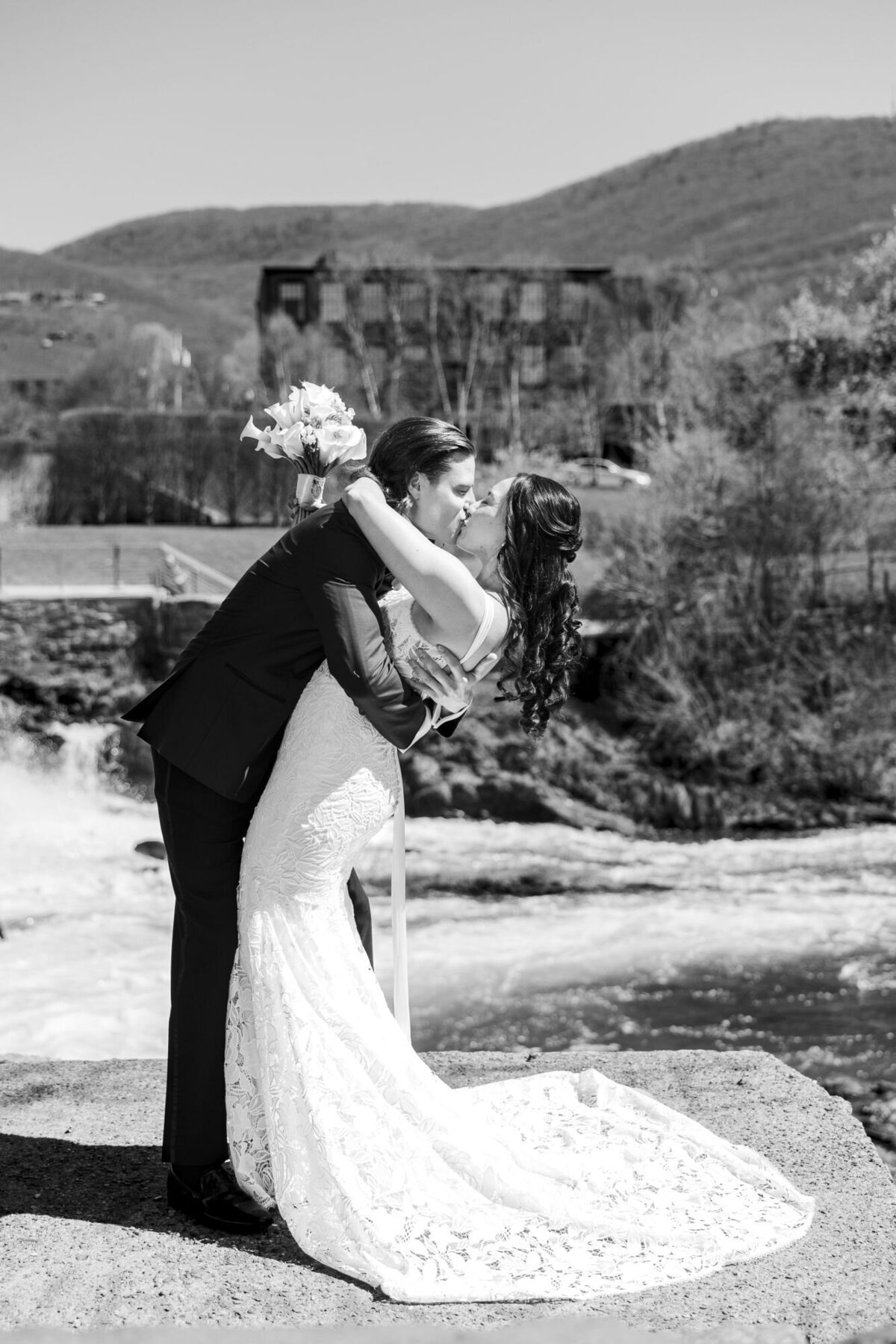 Bride and groom dip during their kiss with Beacon Falls and the Roundhouse Hotel in the background