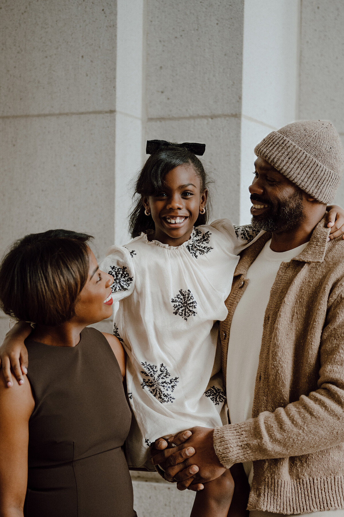 Daughter smiling at the camera while parents look at her 