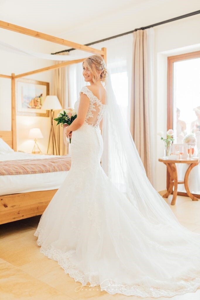 Bride turning back towards the camera wearing long white weddings dress