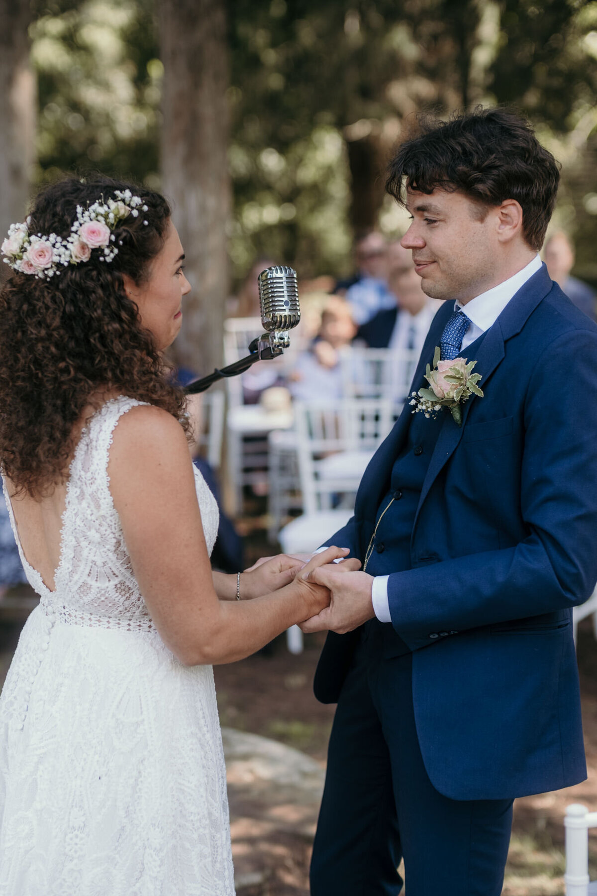 Bride and groom hold hands during their wedding vows.