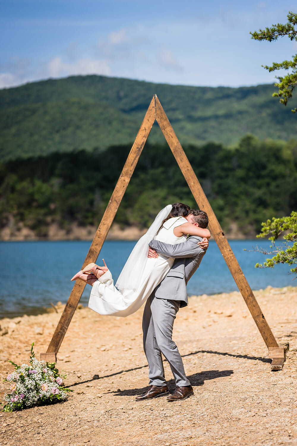 A groom lifts his bride in the air after their first kiss on Carvin’s Cove in Roanoke, Virginia.