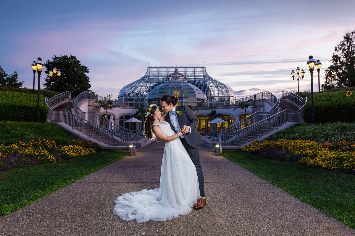 Sunset image of wedding couple dipping in front of phipps conservatory and botanical gardens