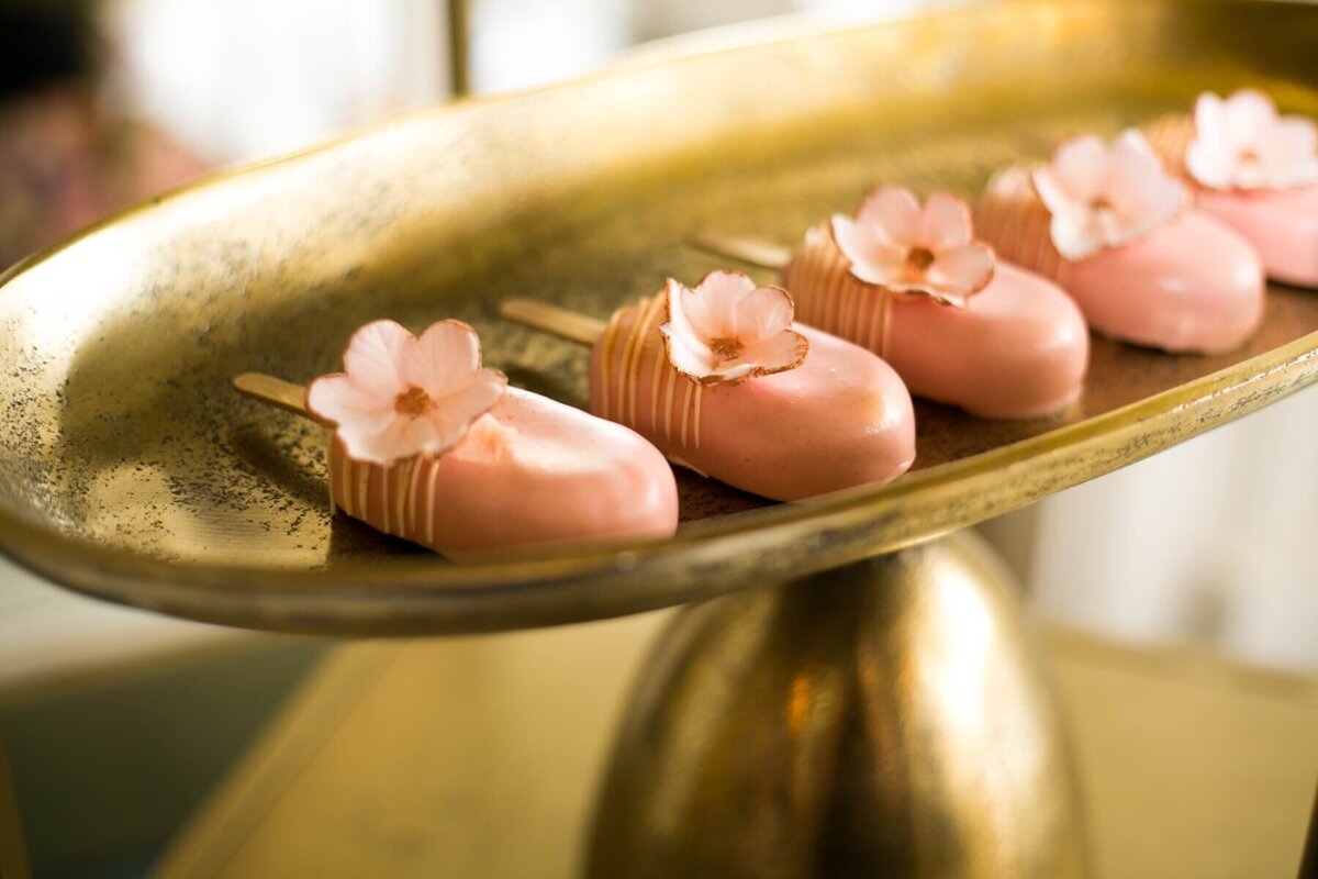 Pretty pink cake pops on a gold plate