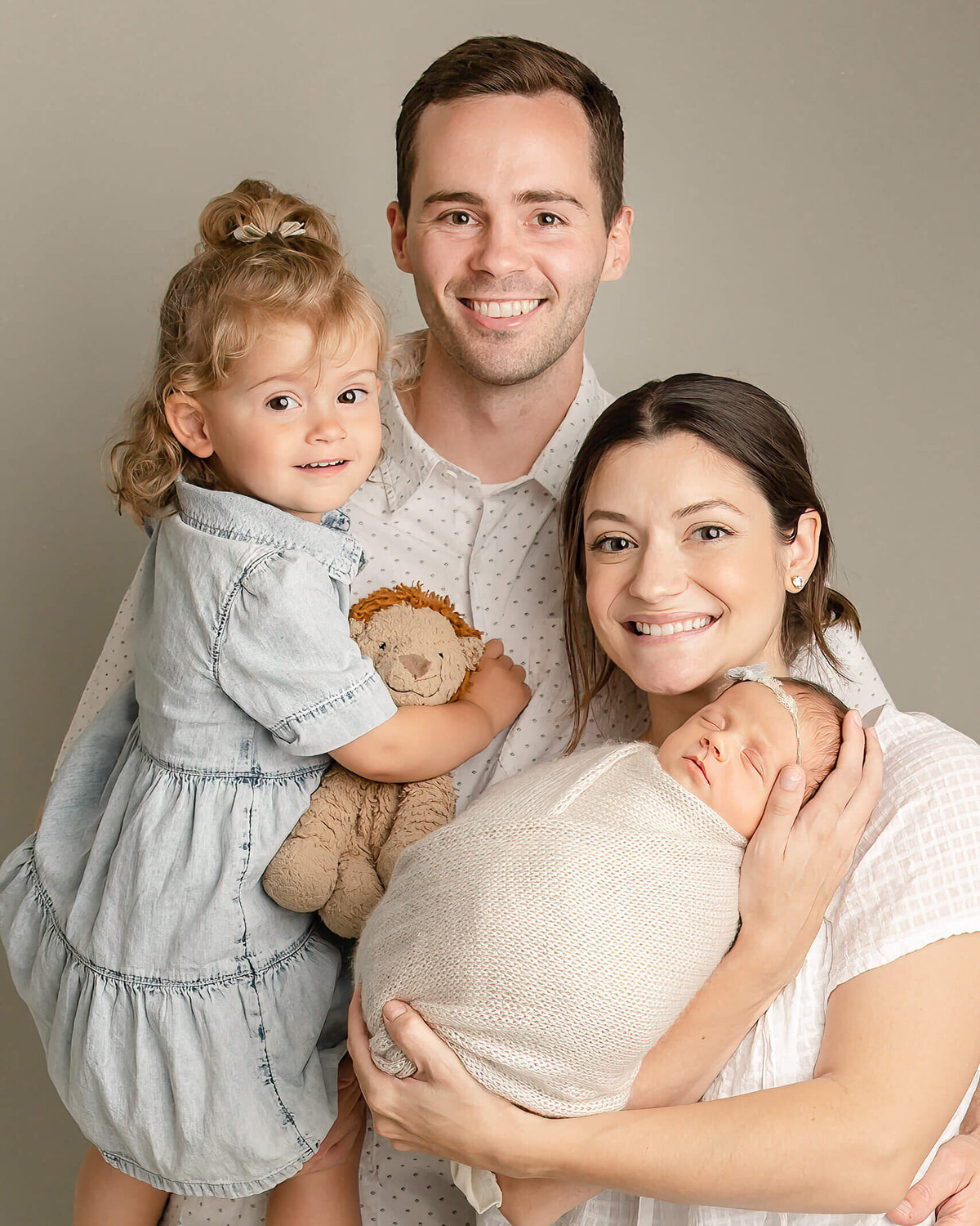 family of four all smiling in portland baby photo in studio
