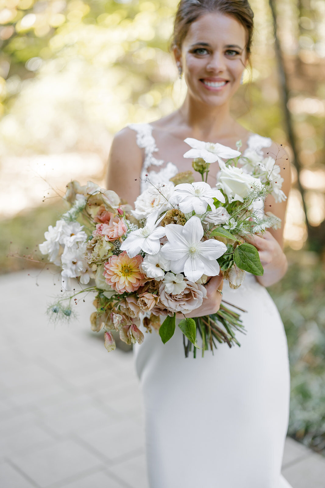 Fall bridal bouquet with lush autumnal colors of mauve, dusty pink, cream, white, peach, taupe, and green. Florals of dahlias, roses, clematis, lisianthus, and natural greenery. Fall wedding in Raleigh, NC. Design by Rosemary and Finch Floral Design in Nashville, TN.
