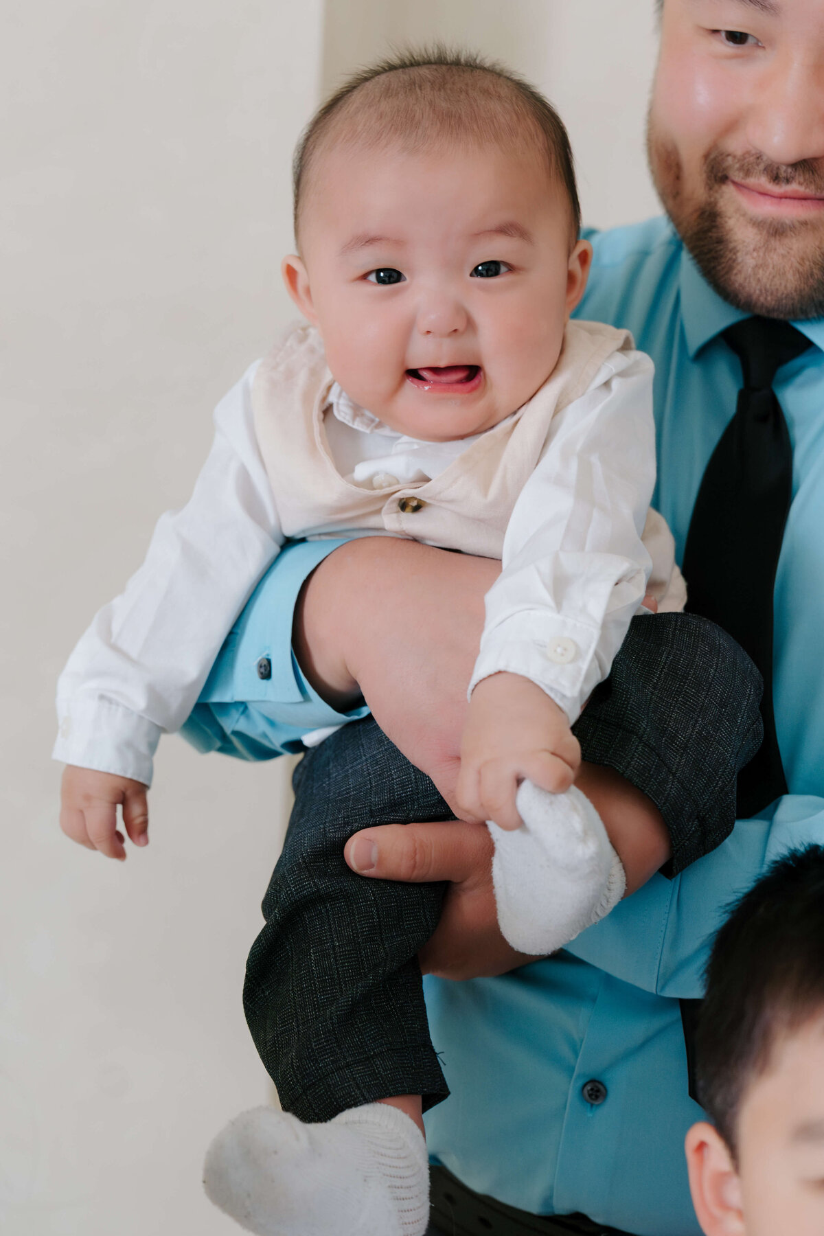 A dad gently embraces a baby, reflecting a beautiful bond of love and nurturing.