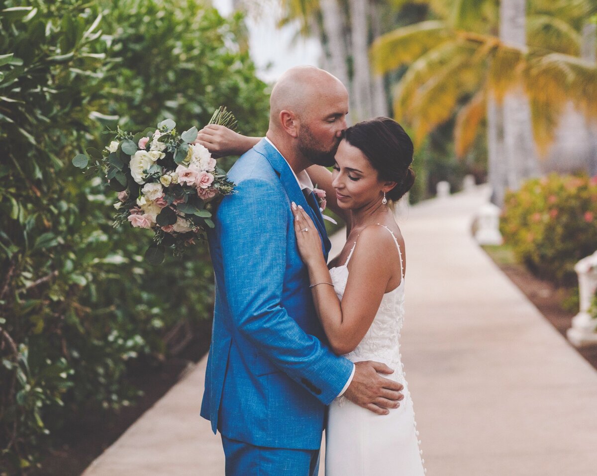 Groom kissing bride on temple at wedding in Riviera Maya