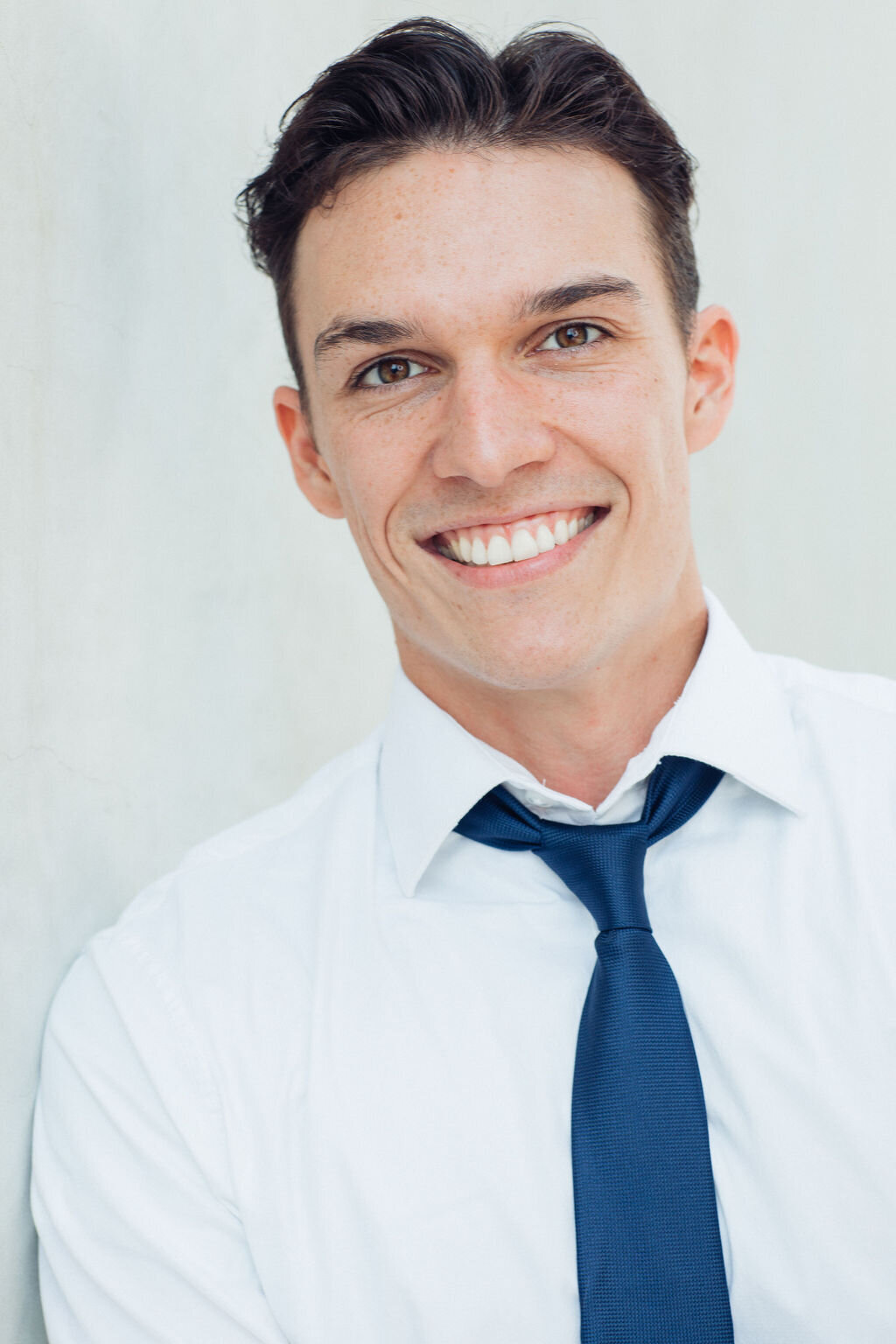 Young Man Wearing White Long Sleeve Polo with Blue Necktie Headshot in LA