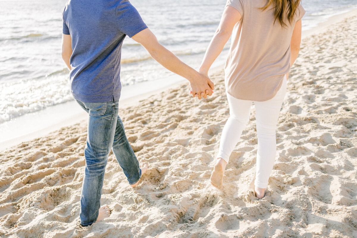 couple holding hands running on a bridge