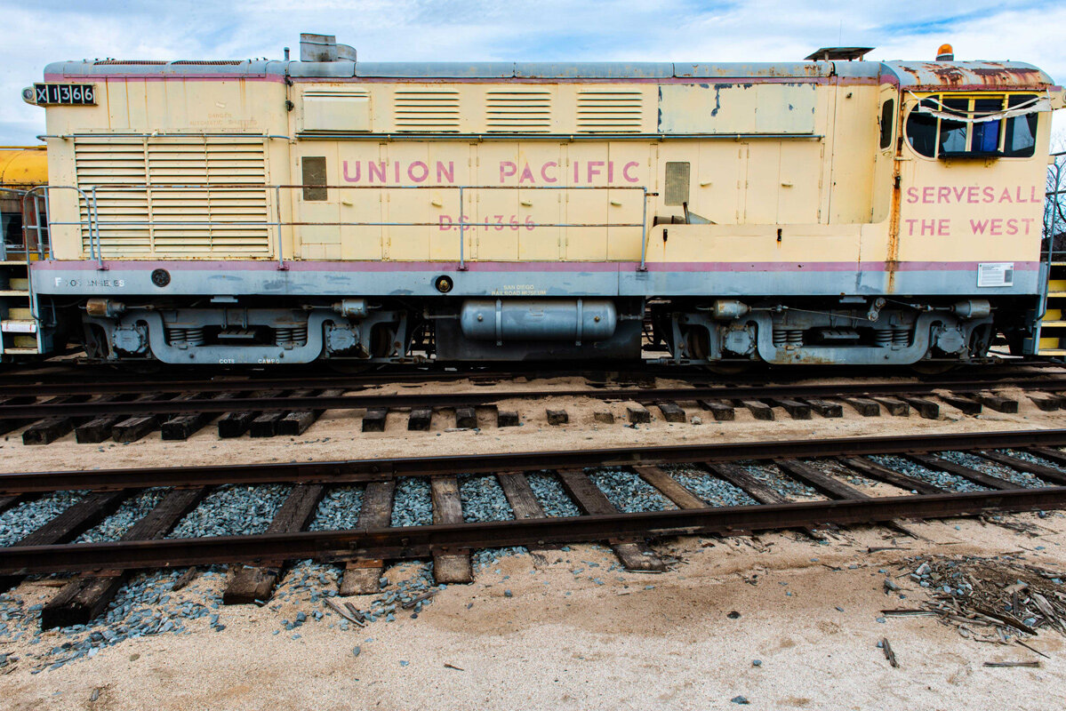An old yellow Union Pacific Train car with rust.