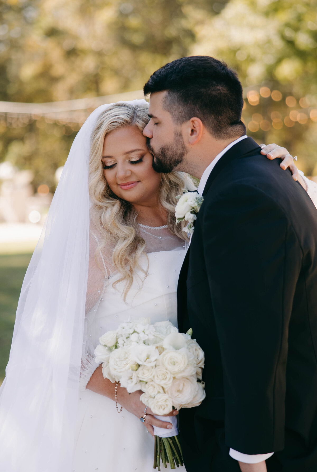 groom kissing brides temple at danclay farms
