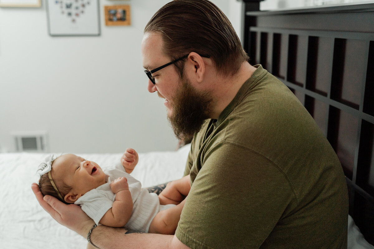 father-bonding-with-newborn-laughing-smiles