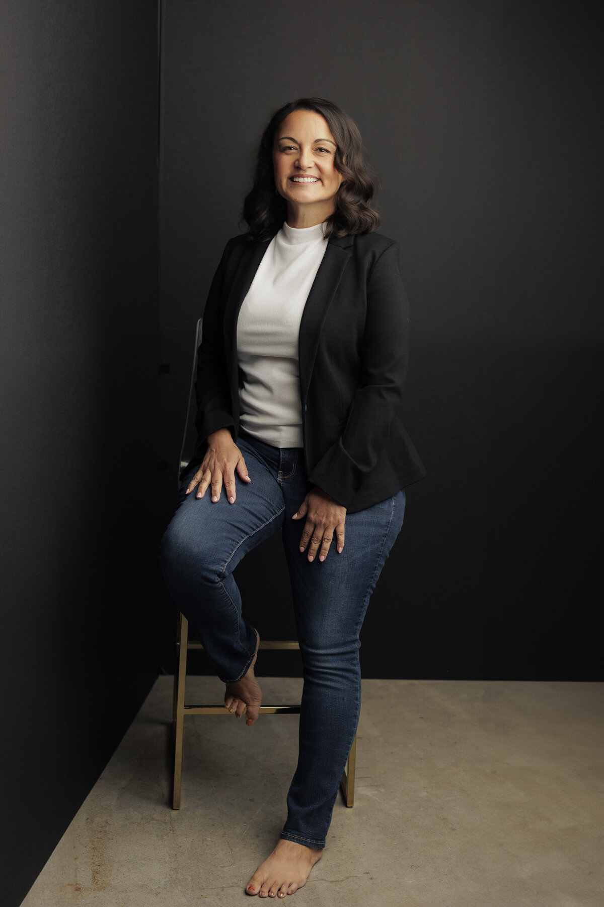 Professional headshot of a confident woman in a modern studio, taken by Haili Barton Photography in Austin, Texas.