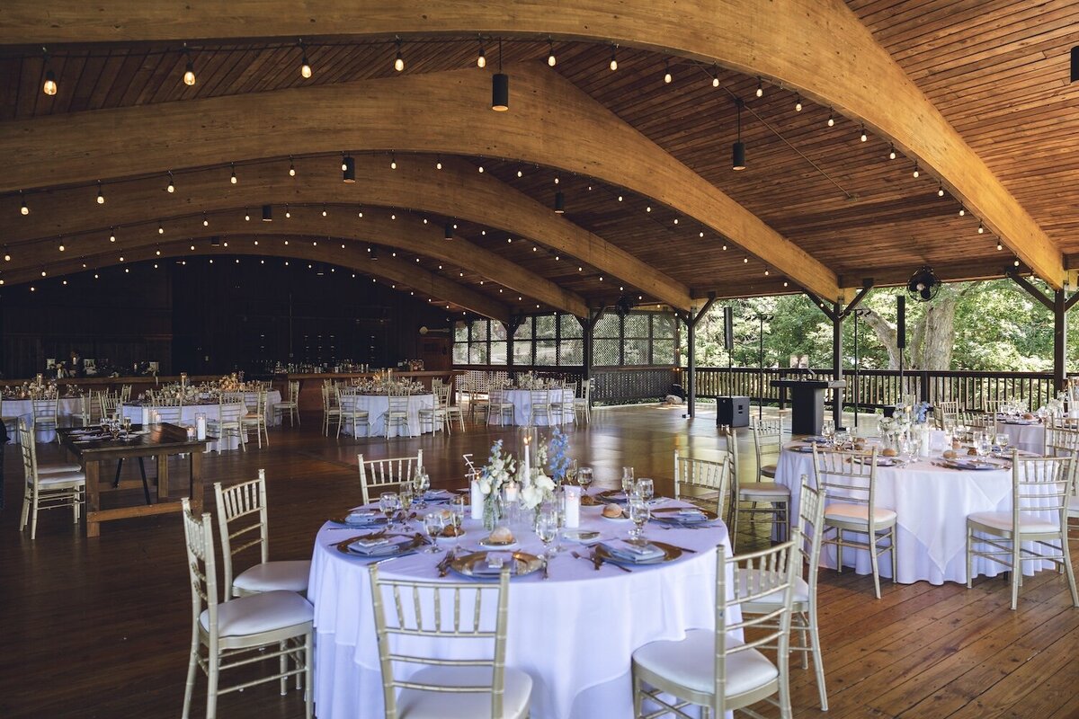 Reception hall with wood beams and round table setup at Crystal Springs Resort