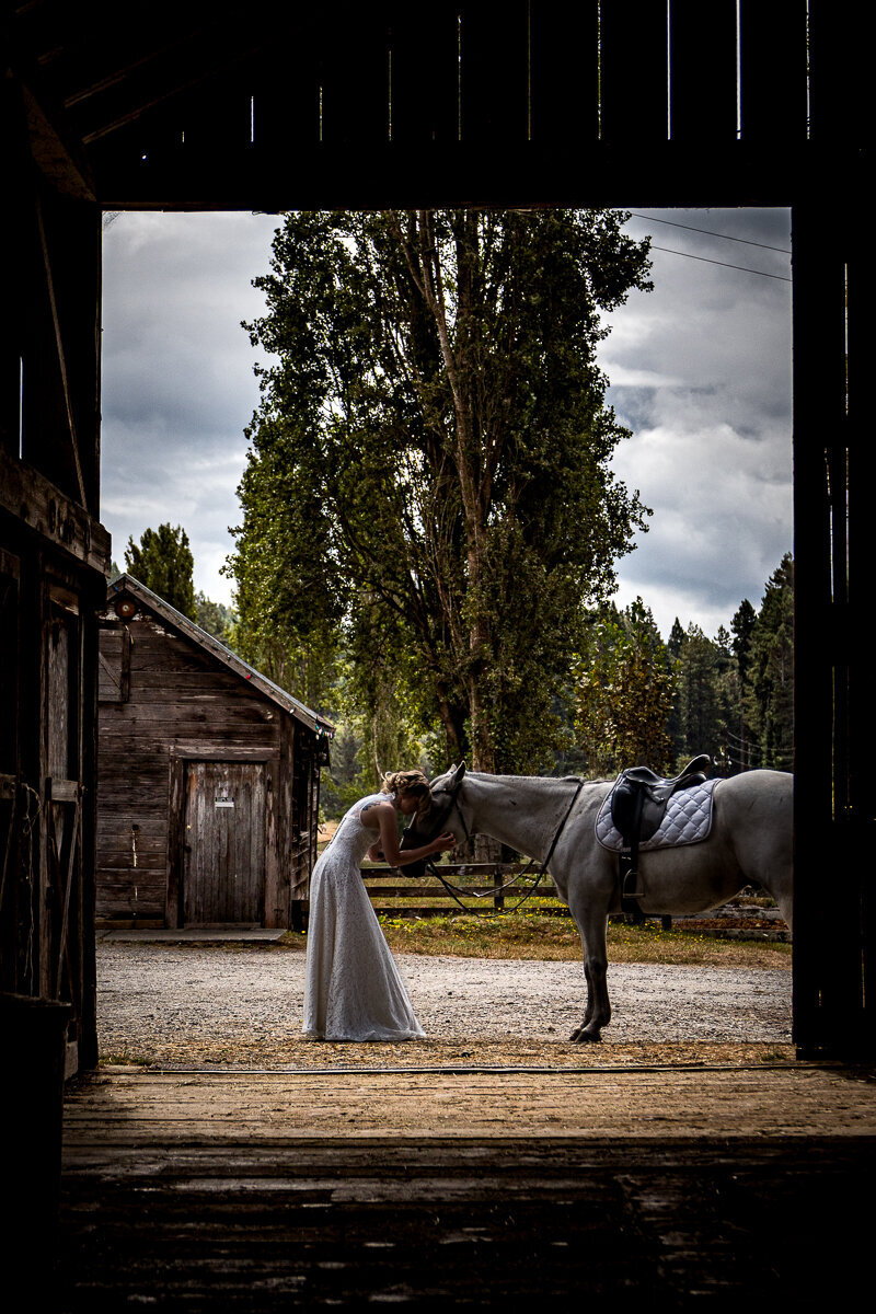 A stunning bride poses with her beloved horse on a picturesque ranch in Arcata, capturing the essence of rustic elegance and unbreakable bonds.