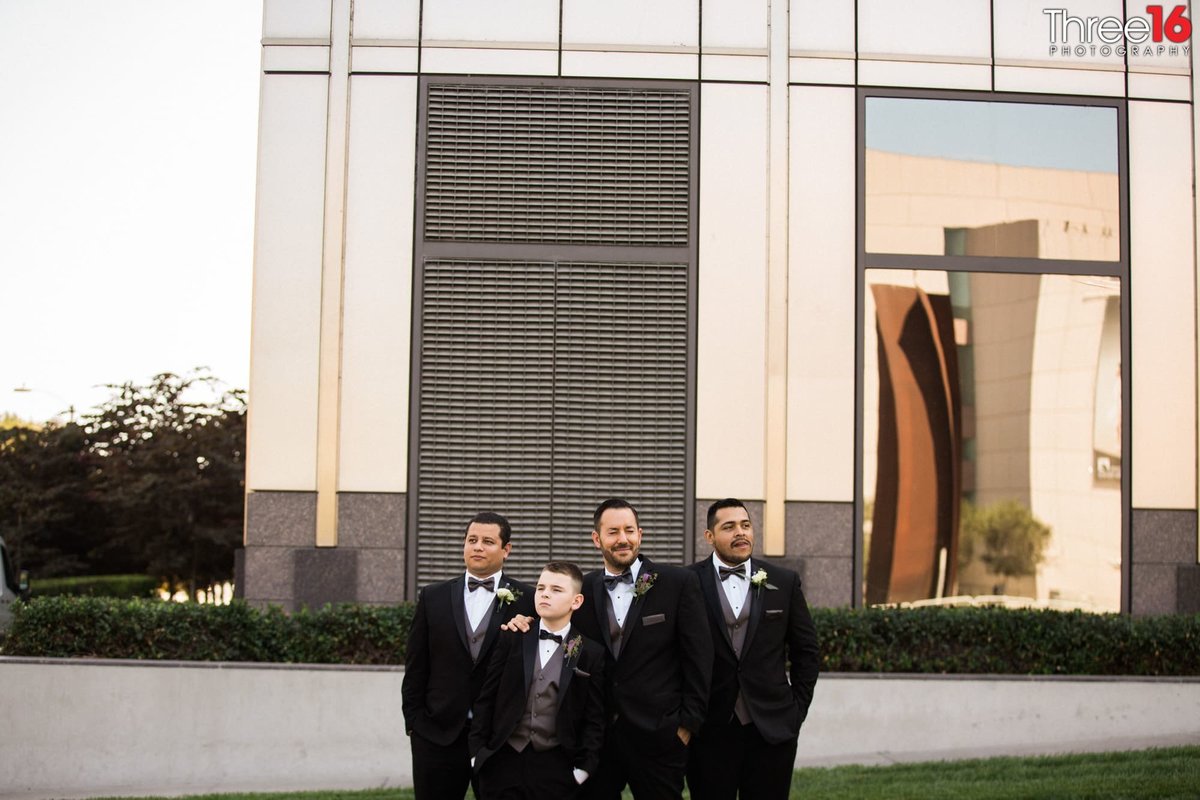 Groomsmen look around at Avenue of the Arts in Costa Mesa, CA