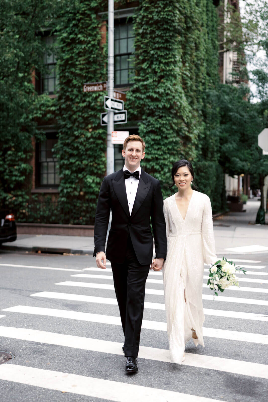 The bride and the groom are holding hands while crossing the street at West Village, NYC. Image by Jenny Fu Studio