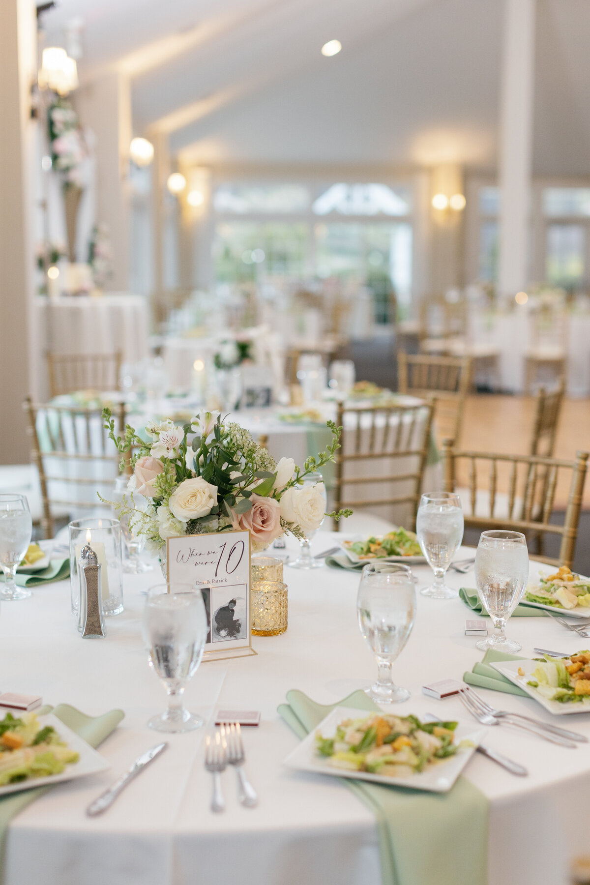 Circular tables are decorated with lavish bouquets and candles for intimate spring wedding