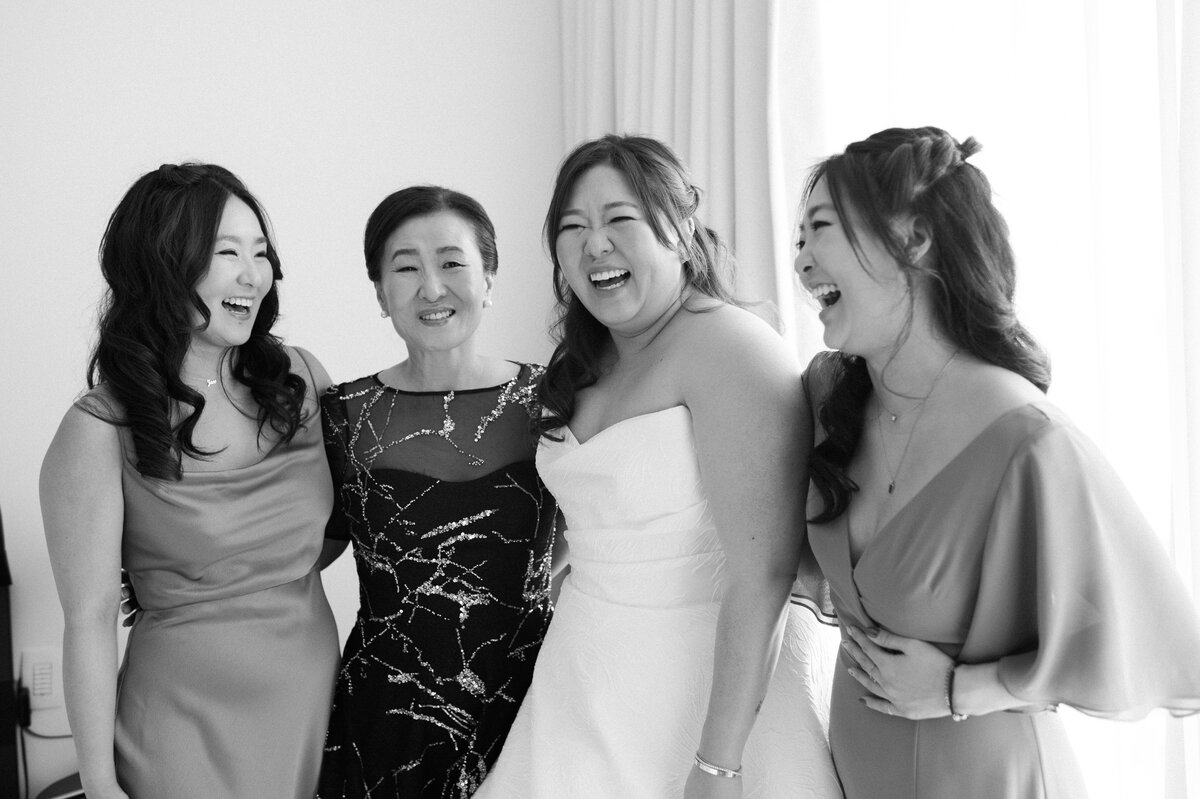 A bride stands and smiles with her family