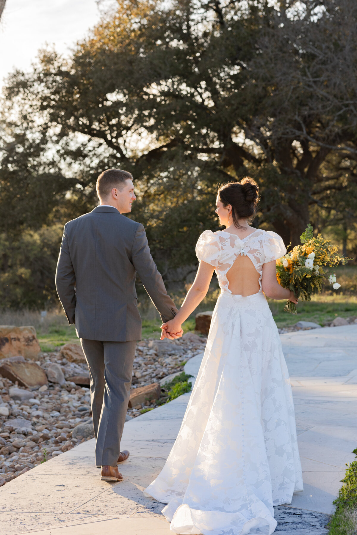 bride and groom holding hands at High Pointe Estate in Austin Texas by Destination wedding photographer Amanda Richardson Photography
