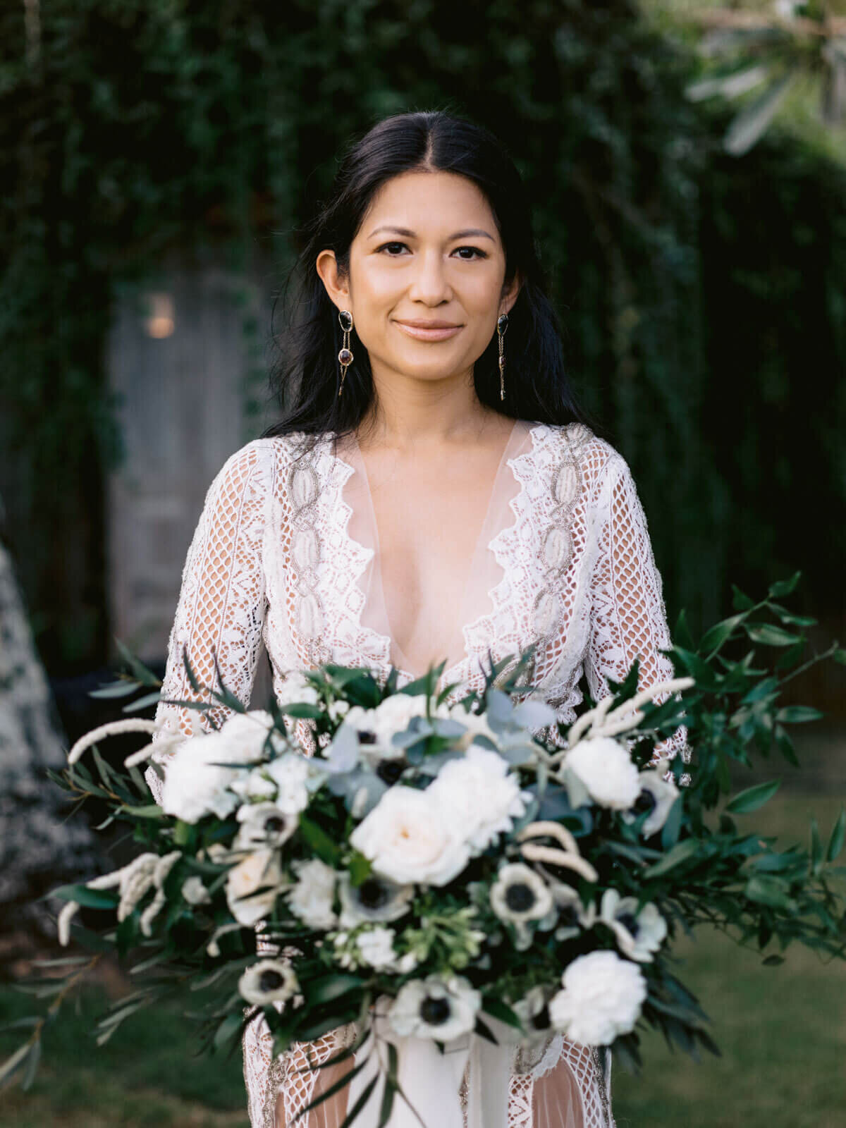 The gorgeous bride is holding her beautiful flower bouquet in Khayangan Estate, Bali, Indonesia. Image by Jenny Fu Studio